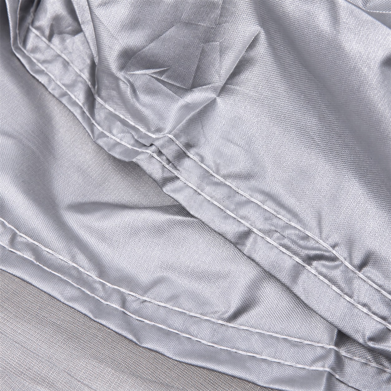 Stitch rows and overlapping silver fabric panels.