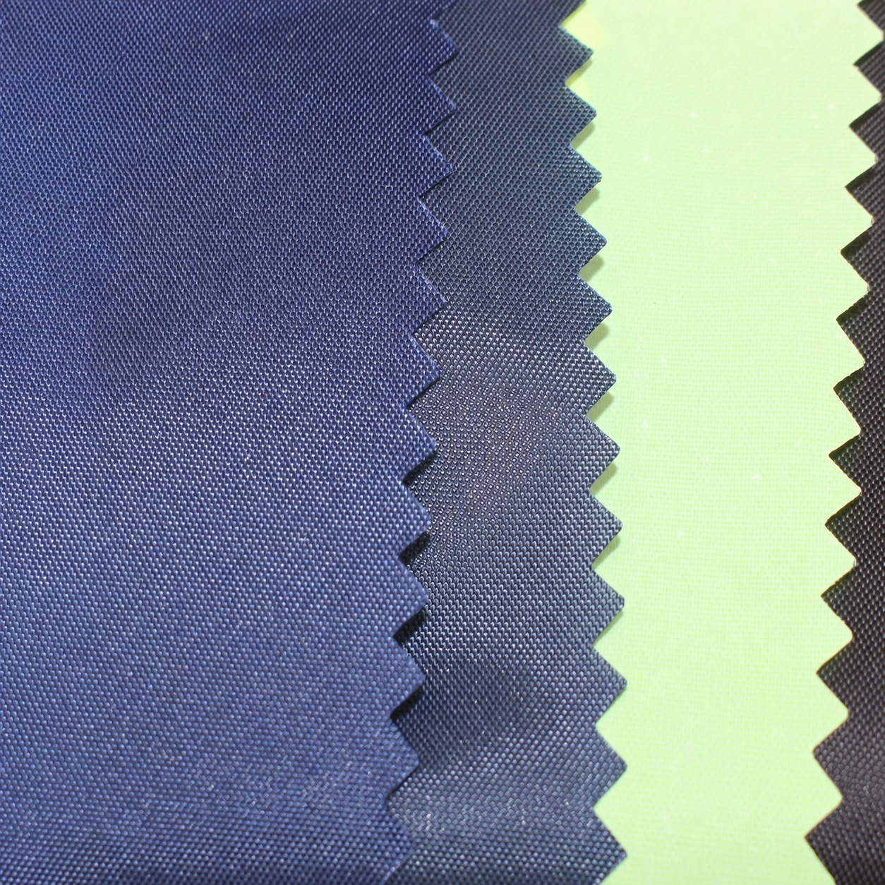 Blue-gray, navy and pale yellow woven fabric swatches with zigzag edges.
