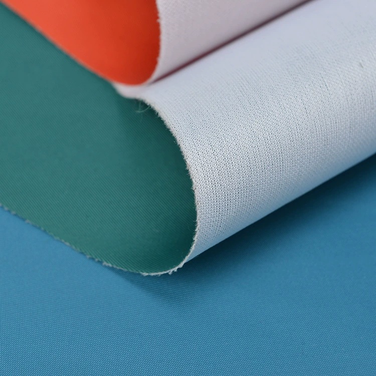 Folded teal, orange and blue fabric with a white reverse and a fine diagonal texture.