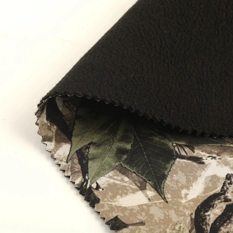 Folded camouflage fabric showing its dark textured backing.