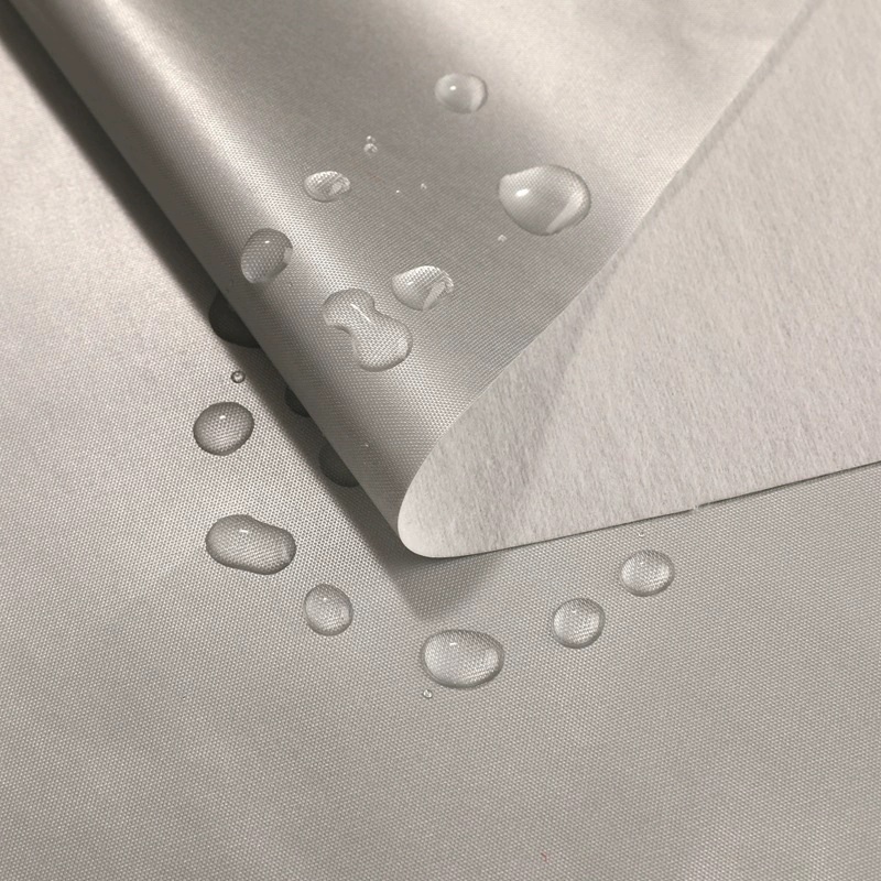 Silver-colored woven fabric with a soft white backing folded over the face and surface droplets.