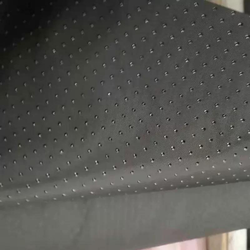 Dark Oxford fabric with an evenly spaced raised dot pattern.