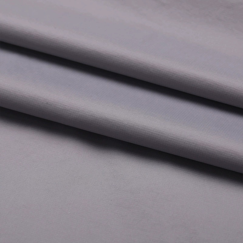 Gray lightweight fabric with soft layered folds and a fine reinforcing grid.