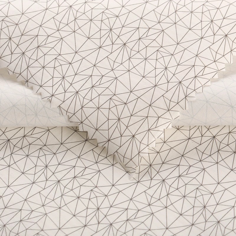 Overlapping white fabric swatches printed with fine gray geometric lines.