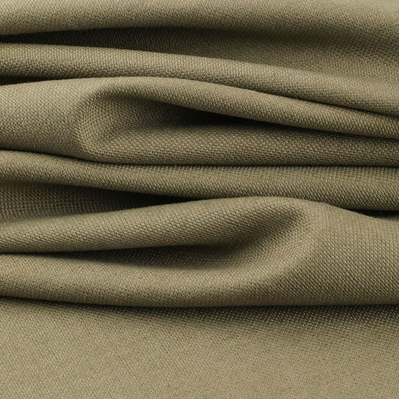 Khaki cotton canvas folded in loose layers with a coarse woven surface.