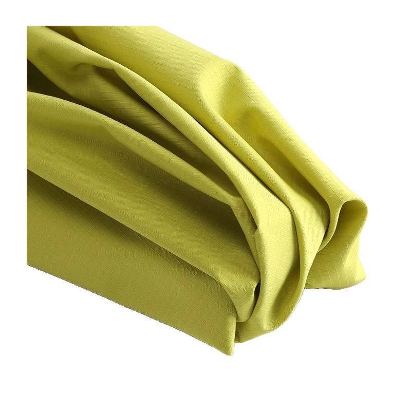 Yellow-green grid fabric gathered in broad folds against a white background.
