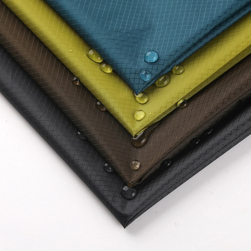 Layered blue, yellow, brown and dark gray fabric swatches with a visible diamond grid and surface droplets.